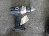 a cordless drill on the ground next to a piece of paper