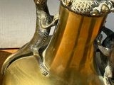 un vase en or orné d'un lézard et d'un autre lézard
