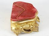 a red and gold box on a white surface