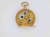 a gold pocket watch on a white surface with a white background