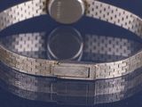 a close up of a silver bracelet with a watch on it