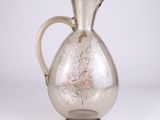 a clear glass pitcher with a floral design on it