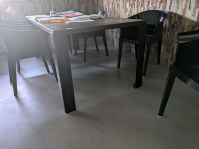 une table et des chaises dans une pièce avec un mur en briques en arrière-plan