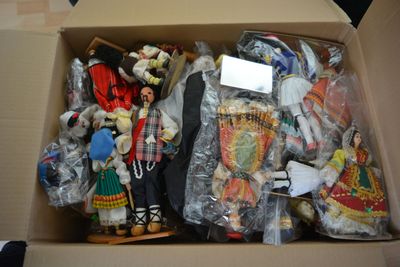 a cardboard box filled with many different types of dolls