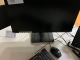 un écran d'ordinateur et un clavier posés sur une table