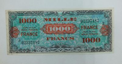 un gros plan d'un billet de banque posé sur une surface blanche