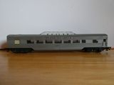 un petit train miniature posé sur une table, avec un mur blanc en arrière-plan