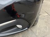 a close up of a car door handle with a reflection of a person in the background