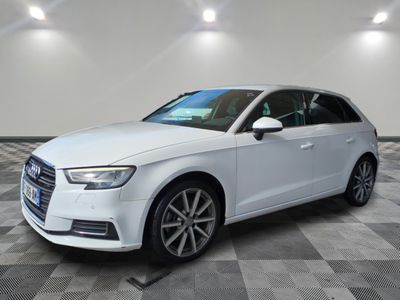 Une Audi blanche est garée sur un sol en carrelage à damier.
