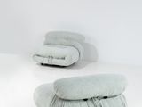 une pièce blanche avec deux chaises et deux coussins posés par terre