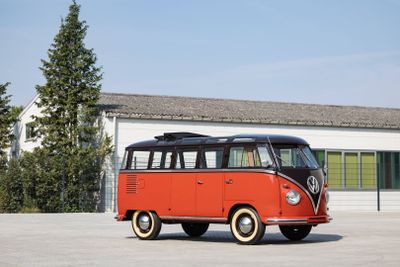 un minibus Volkswagen rouge et noir garé devant un immeuble