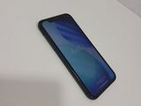 a close up of the back of a black phone on a white table