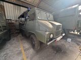 a military truck parked in a garage with other military vehicles in the background