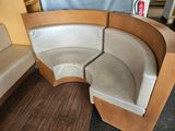 a corner couch with a curved seat in the middle of the room