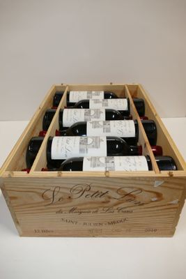 bouteilles de vin dans un coffret en bois sur une surface blanche