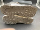 someone is holding a pair of shoes that are on a table