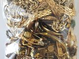 a bag full of gold jewelry on a white surface