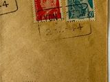 an old brown envelope with stamps on it sitting on a table