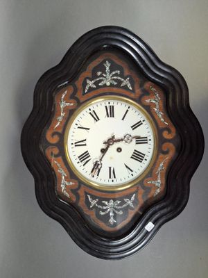 a clock hanging on the wall with roman numerals on it