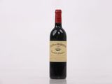 une bouteille de vin rouge posée sur une table blanche
