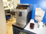 une machine à café posée sur une table, à côté d'un paquet de café