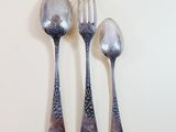 three spoons and a fork on a white surface