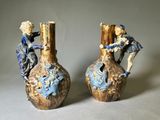 deux vases ornés de personnages, posés sur une table