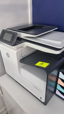 une imprimante posée sur un bureau à côté d'un téléphone portable