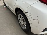 a white car that has been damaged and is parked in a parking lot