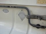 a close up of a metal handle on a white stove