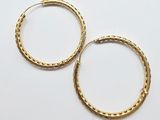 a pair of gold hoop earrings on a white background
