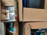 Plusieurs cartons remplis de livres sont empilés les uns sur les autres par terre.
