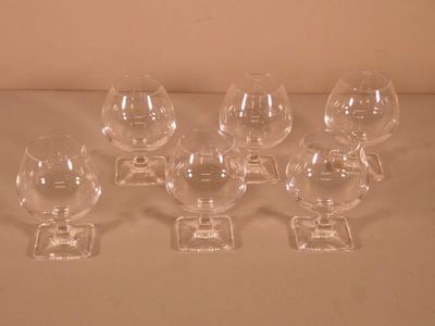 six verres à vin vides posés sur une table