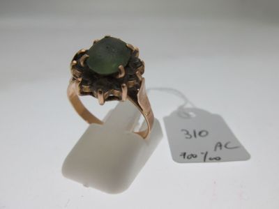 a close up of a ring with a green stone in it