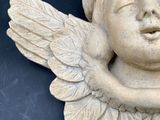 a statue of a baby with wings on a black surface