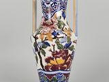 a vase with a floral design on it sitting on a table