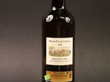 a bottle of wine sitting on top of a table next to a bottle of wine