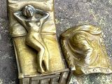 une statue représentant une femme allongée sur un lit, à côté d'un oreiller