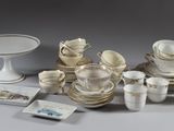 beaucoup d'assiettes, de tasses et de soucoupes blanches et dorées