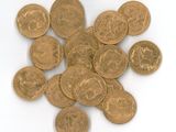 a pile of gold coins on a white surface