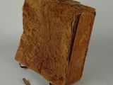 un petit sac marron posé sur une surface blanche