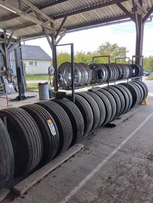 many tires stacked up on a pallet in a garage