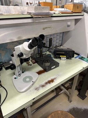 un microscope posé sur une table dans une pièce encombrée