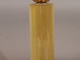 a bottle of perfume that has a gold ball on top of it