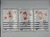three silver coins in plastic bags on a white surface