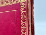 a red book with a gold border on it