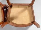 a wooden chair with a seat that has a cushion on it