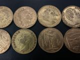 six different british coins sitting on a black surface