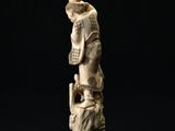 an old ivory figurine of a man with a hat on his head