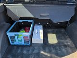 the back of a car with a basket of fruit in the trunk